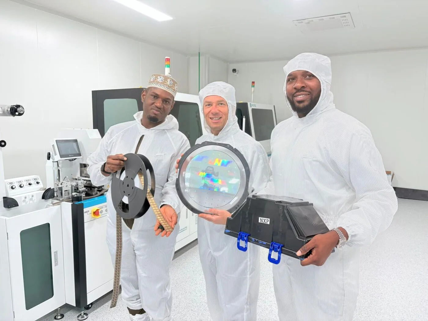 ASMC engineers holding a wafer, component reel and packaging